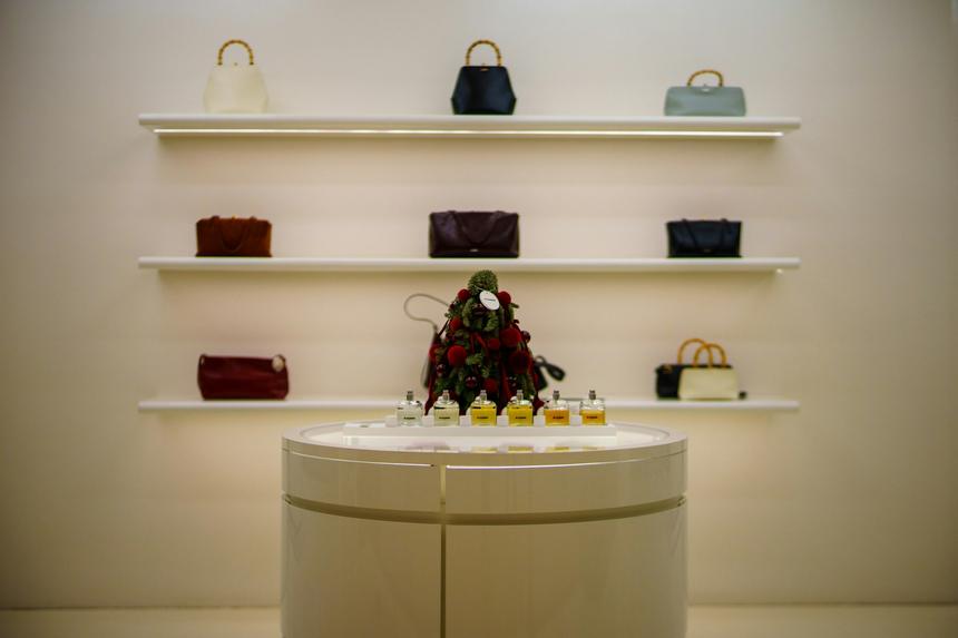 Cream boutique interior with handbags arranged on rounded shelves.